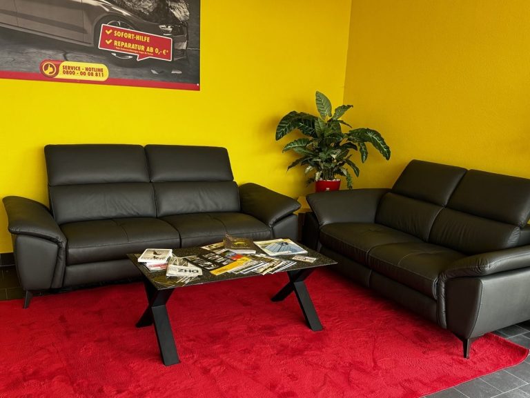 Persönlicher Empfang beim Scheiben-Doktor Halle Empfangs- und Wartebereich beim Scheiben-Doktor Halle mit Sitzgruppe in den Markenfarben Rot und Gelb
